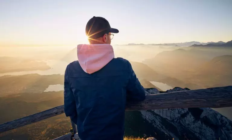 Hiker looking at mountain range at sunrise