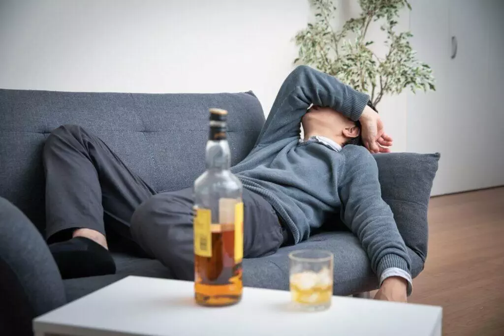 drunk man lying on couch after work
