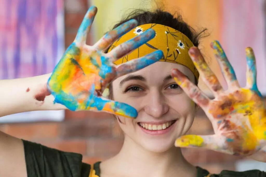 woman with paint all over her hands